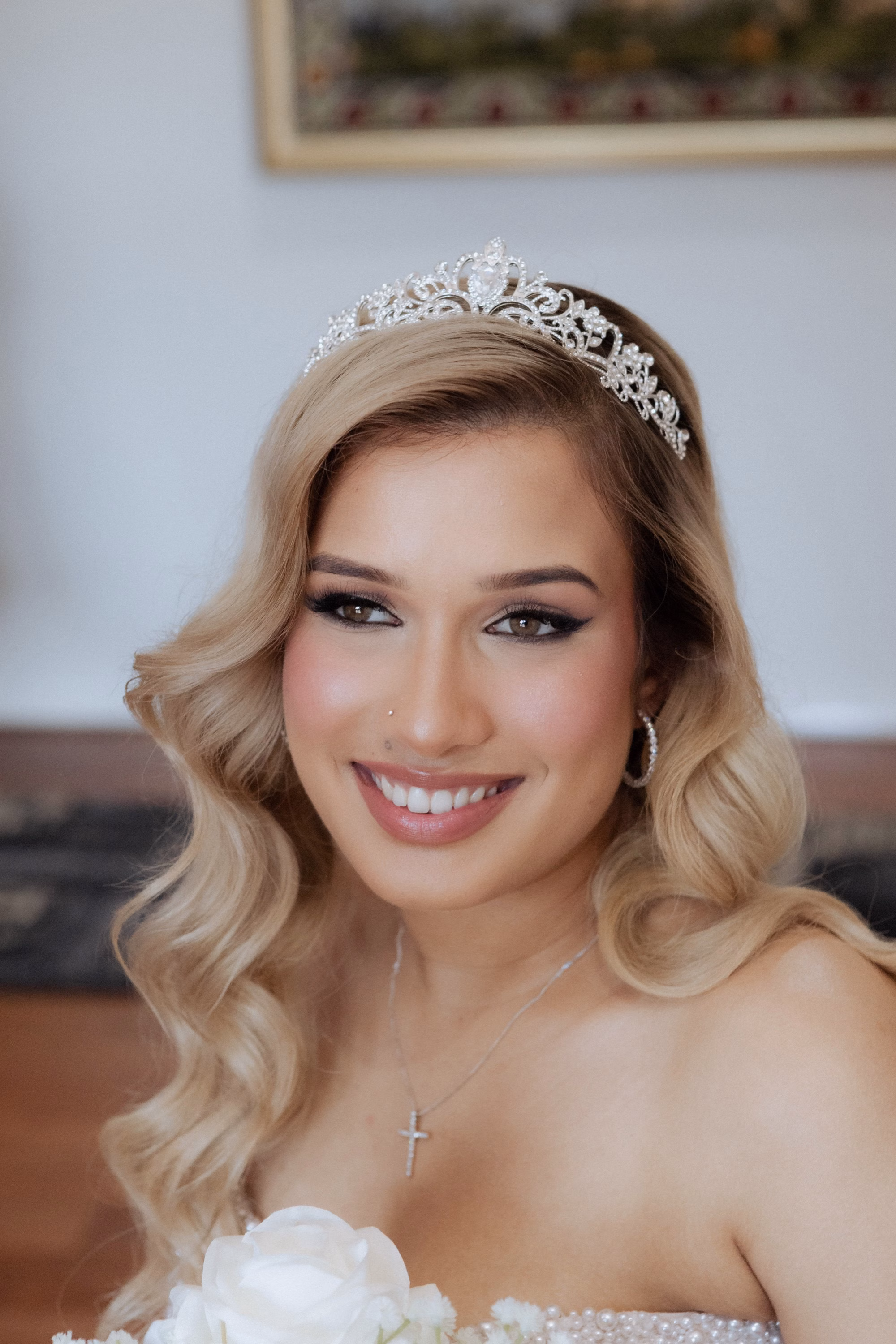 A bride smiling after makeup has been applied