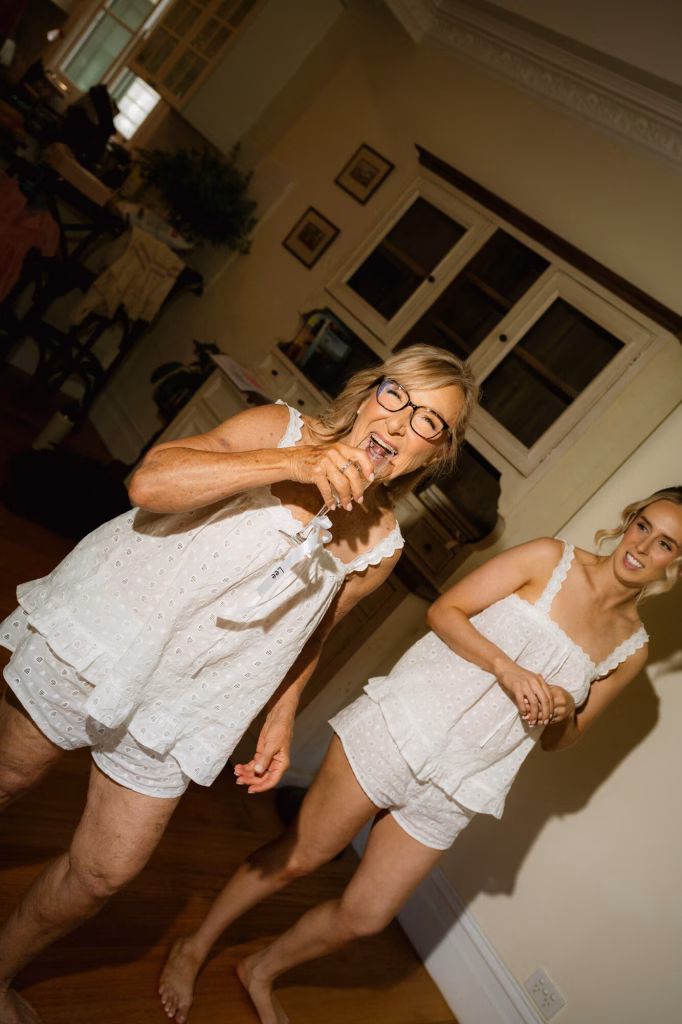 The bride's mother laughing with the bridal party during the morning